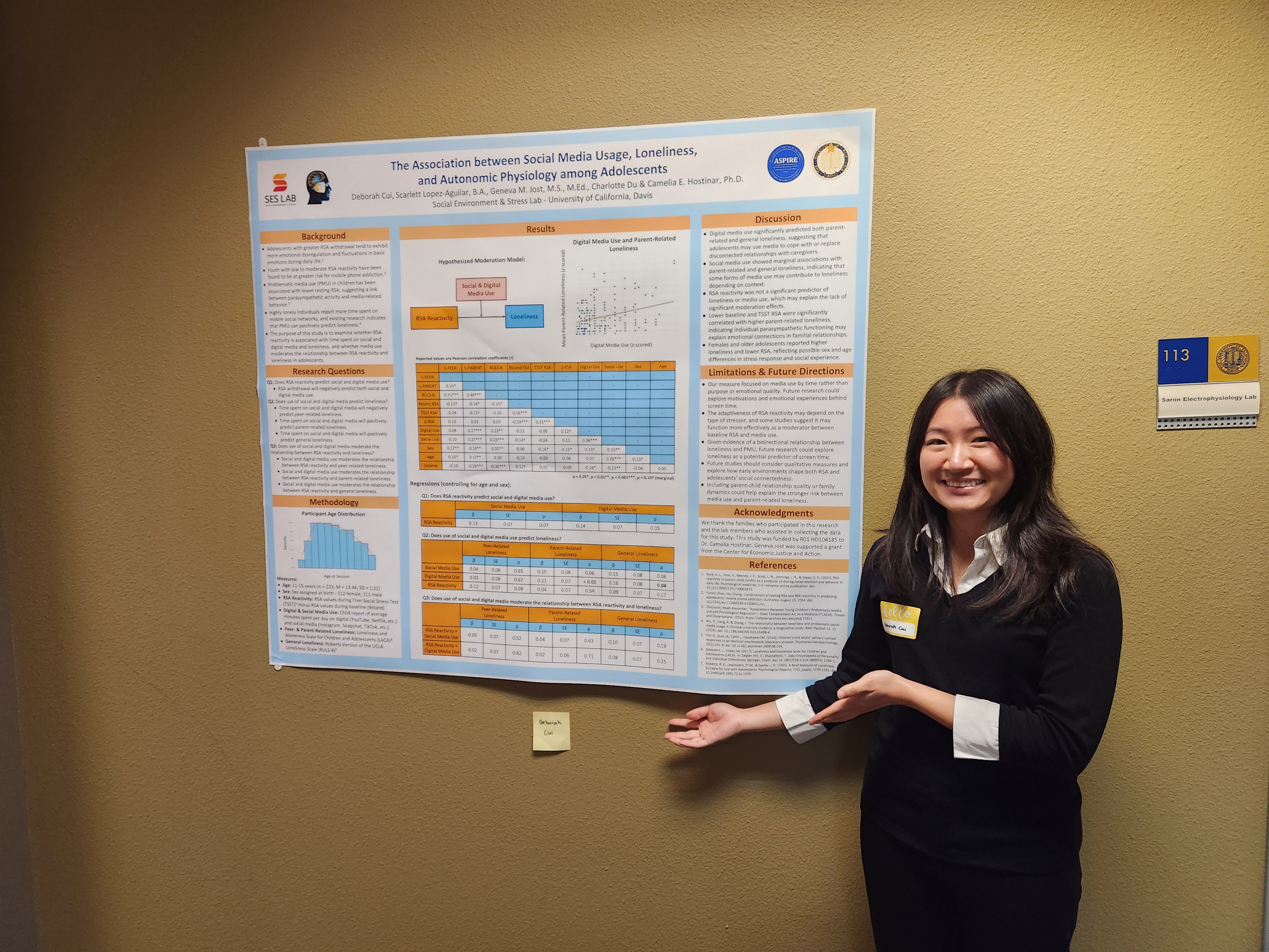 A student at a poster shows off their research.